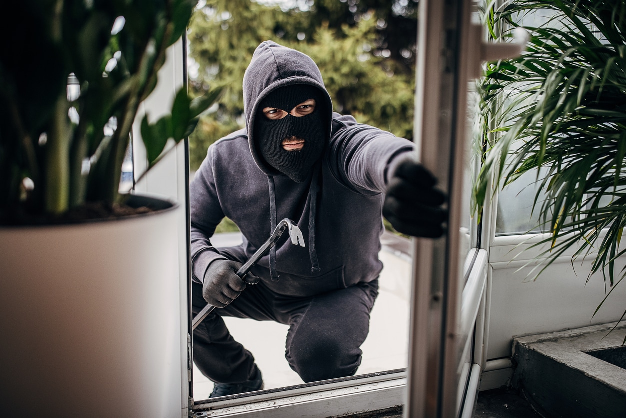 Robber breaking in house - theft defense lawyer concept.