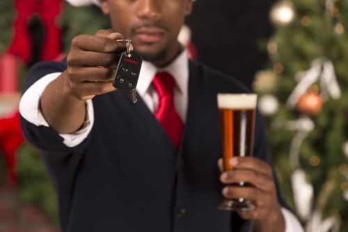 African American handing over car keys while drinking