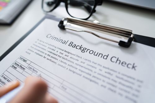 Hand Filling Criminal Background Check Application Form - Expunge Criminal Record Concept